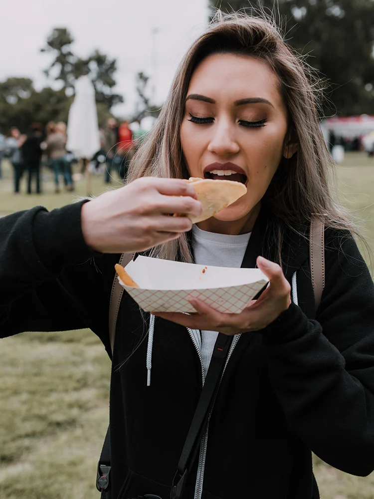 young-woman-holding-takeout-food-eating-biting-tac-2024-12-06-03-55-40-utc copy